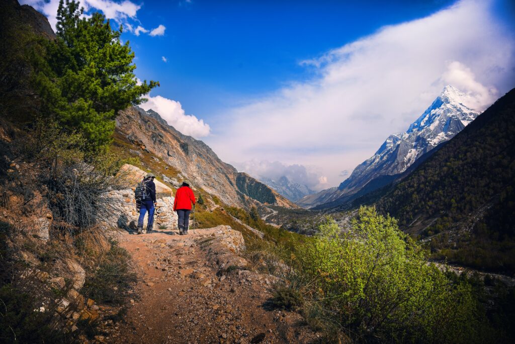 two people hike on a mountain road